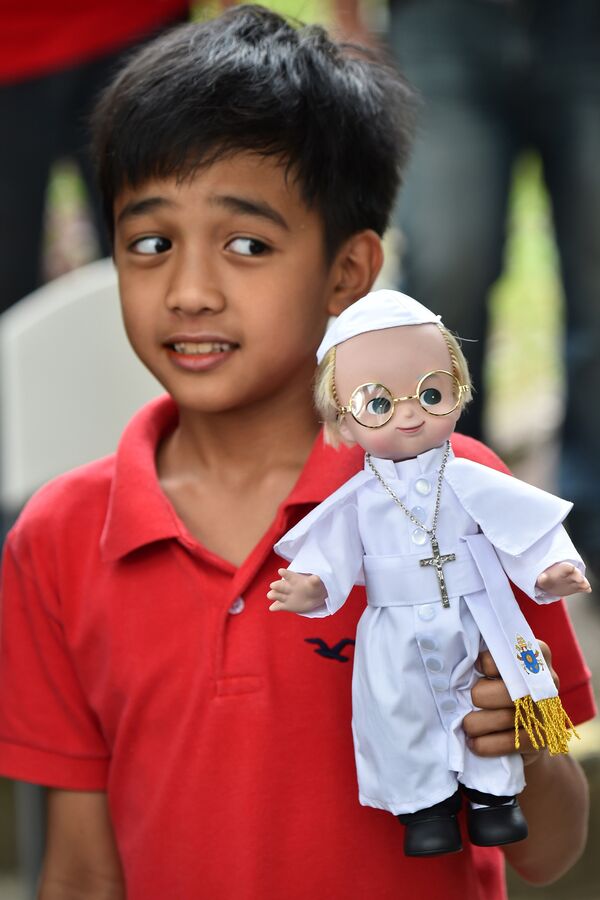 Мальчик держир куклу Папы Римского Франциска в Маниле