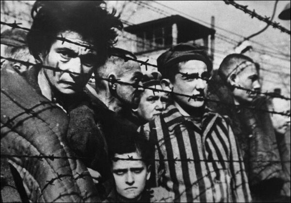 Заключенные за колючей проволокой в концентрационном лагере Освенцим