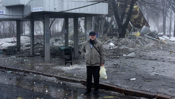 Мужчина на автобусной остановке в Донецке, разрушенной в результате обстрела