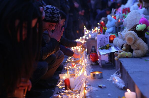 Свечи и цветы в память о семье, убитой в Гюмри. Ереван, Армения