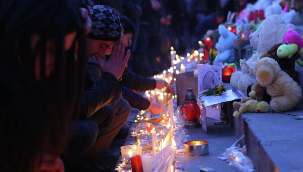 Свечи и цветы в память о семье, убитой в Гюмри. Ереван, Армения