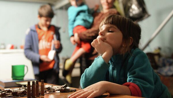 Девочка играет автоматными гильзами в подвале 21-й городской больницы, где она живет с родителями