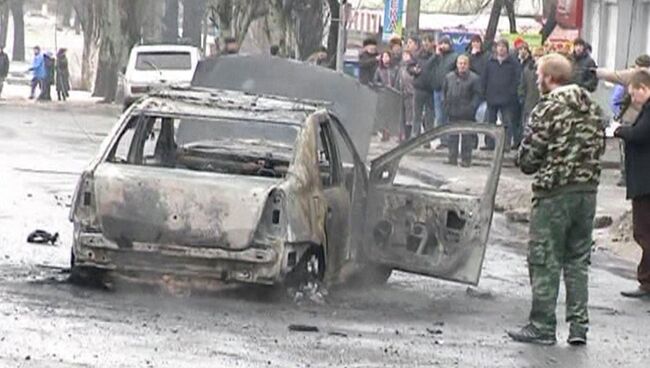 Сгоревший автомобиль недалеко от обстрелянной остановки транспорта в Донецке