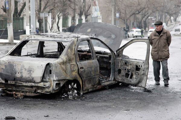 Сгоревший автомобиль недалеко от обстрелянной остановки транспорта в Донецке