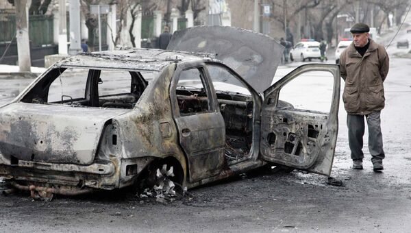 Сгоревший автомобиль недалеко от обстрелянной остановки транспорта в Донецке