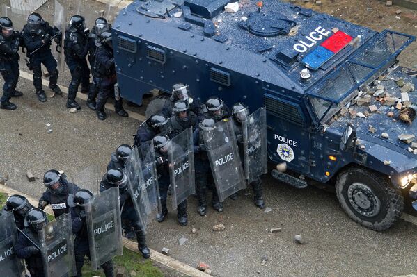 Полиция защищается от камней в ходе столкновений с участниками акции протеста в Приштине, Косово. 27 января 2015 год