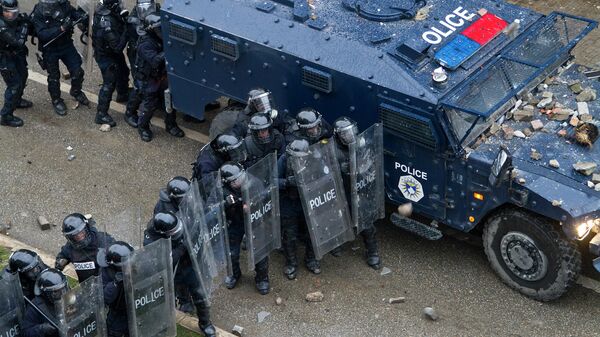Полиция защищается от камней в ходе столкновений с участниками акции протеста в Приштине, Косово. Архивное фото