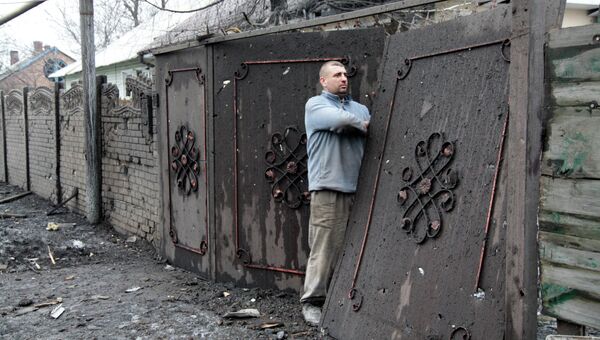 Житель Донецка ремонтирует ворота частного дома, пострадавшего в результате обстрела в Петровском районе. Архивное фото