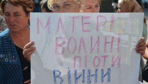 Женщина с плакатом Матери Волыни против войны во время акции у Верховной Рады Украины