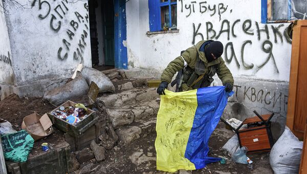 Ополченец держит флаг Украины, найденный на КПП. Восточная Украина. 24 января 2015