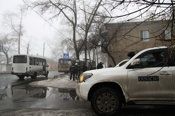 Автомобиль сотрудников ОБСЕ у дома, разрушенного в результате артиллерийского обстрела