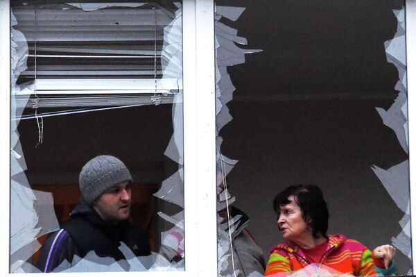 Выбитые окна у пострадавшего от обстрела жилого многоэтажного дома в Донецке