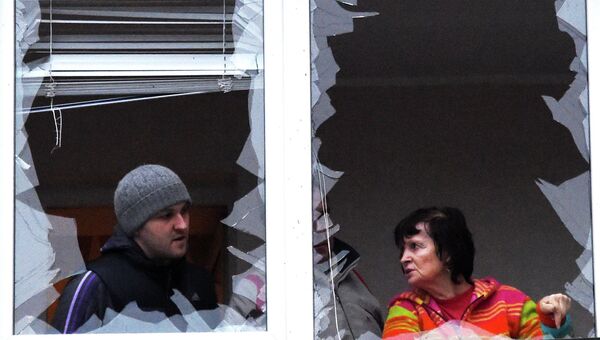 Выбитые окна у пострадавшего от обстрела жилого многоэтажного дома в Донецке