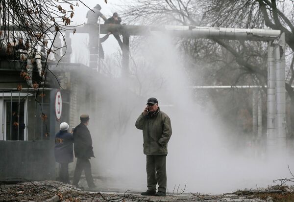 Рабочие ремонтируют поврежденную в результате обстрела теплотрассу в Донецке