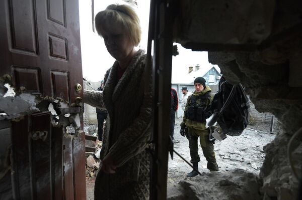 Ополченец у разрушенного в результате обстрела дома в Донецке