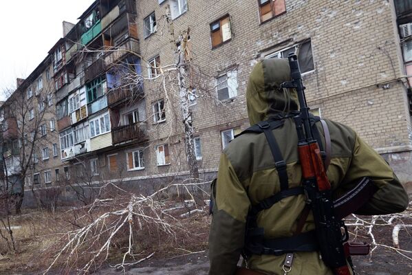 Ополченец у разрушенного в результате обстрела дома в пригороде Донецка