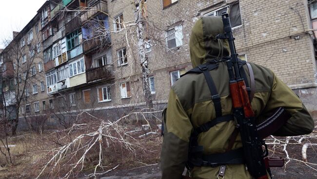 Ополченец у разрушенного в результате обстрела дома в пригороде Донецка. Архивное фото