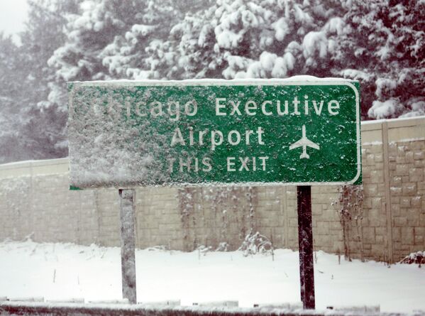 Дорожный знак на дороге недалеко от аэропорта О'Хара во время снегопада в Чикаго