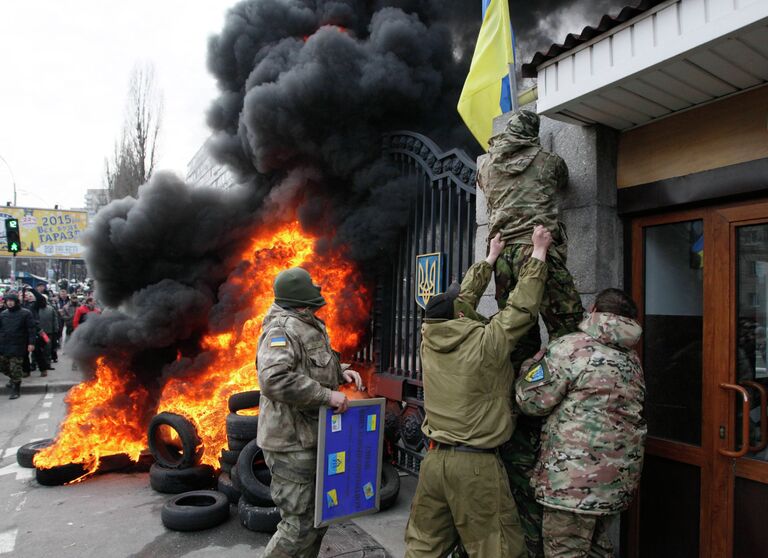 Военнослужащие из батальона Айдар снимают украинский флаг со здания Министерства обороны Украины