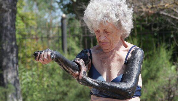Женщина отдыхающая на Черноморском побережье Крыма в городе Саки, известным своими грязелечебницами. Архивное фото