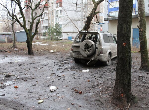 Искореженный в результате обстрела легковой автомобиль в городе Донецке
