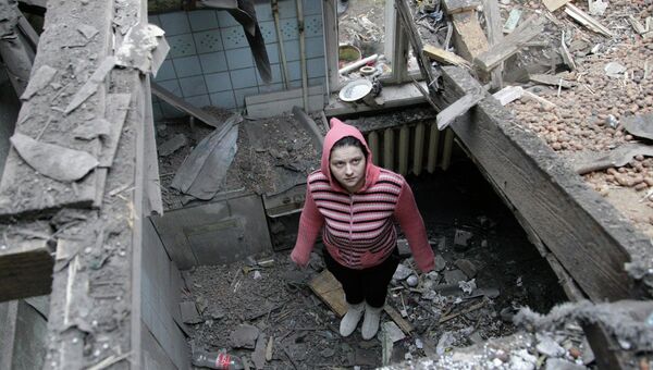 Женщина осматривает разрушенный дом после обстрела Донецка. Архивное фото