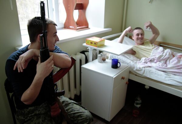Раненый украинский военный общается с охраняющим его ополченцем в одной из больниц Донецка