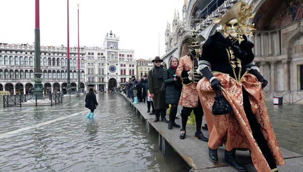 Участники карнавала во время наводнения в Венеции