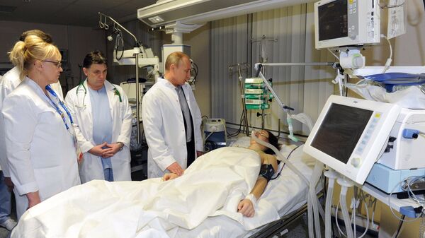 Президент России Владимир Путин во время посещения российской спортсменки Марии Комиссаровой