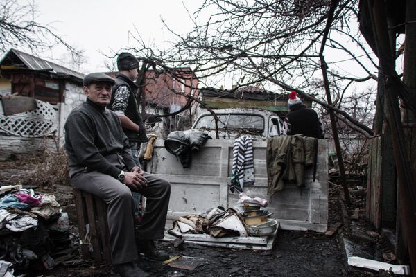 Жители во дворе дома, пострадавшего в результате обстрела Куйбышевского района Донецка