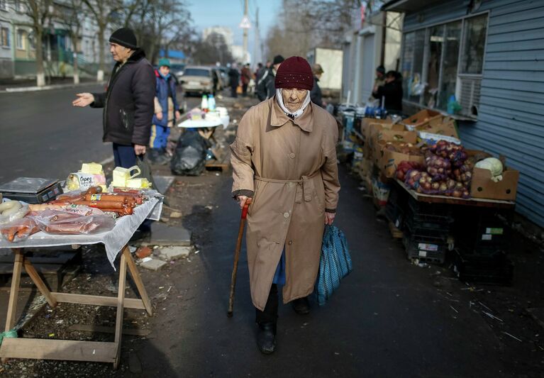 Женщина проходит мимо рынка в Мариуполе 3 февраля 2015