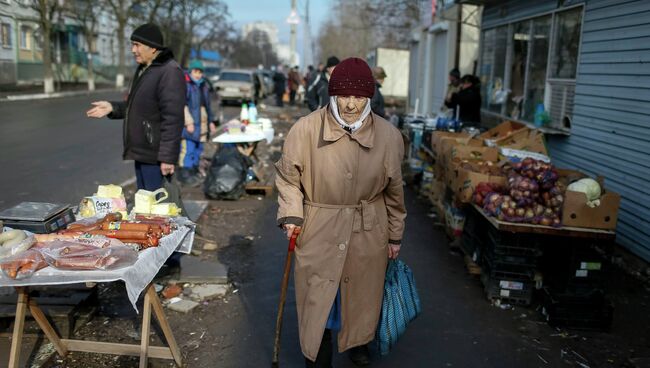 Женщина проходит мимо рынка в Мариуполе 3 февраля 2015