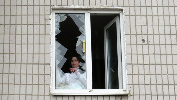 Жительница Донецка у разбитого в результате обстрела окна неподалеку от 27-ой больницы