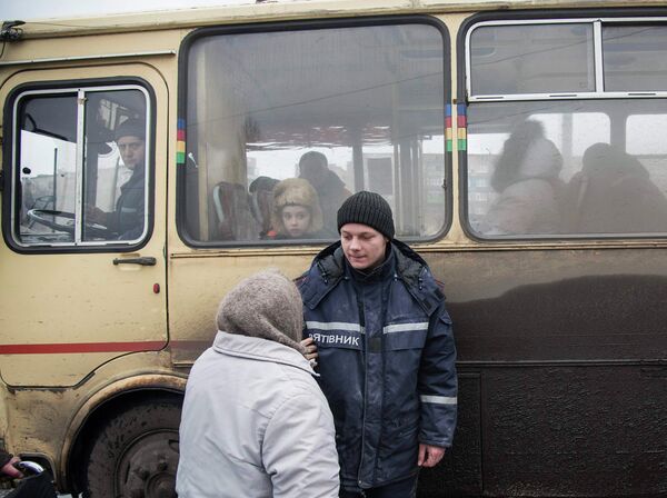 Пожилая женщина беседует с сотрудником МЧС перед посадкой в автобус, чтобы покинуть зону вооруженного конфликта. Дебальцево, Украина, 4 фераля 2015