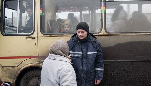 Пожилая женщина беседует с сотрудником МЧС перед посадкой в автобус, чтобы покинуть зону вооруженного конфликта. Дебальцево, Украина, 4 фераля 2015