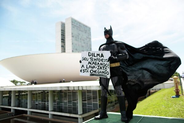 Человек в костюме Бэтмена держит табличку в качестве протеста против вновь избранных депутатов парламента Бразилии