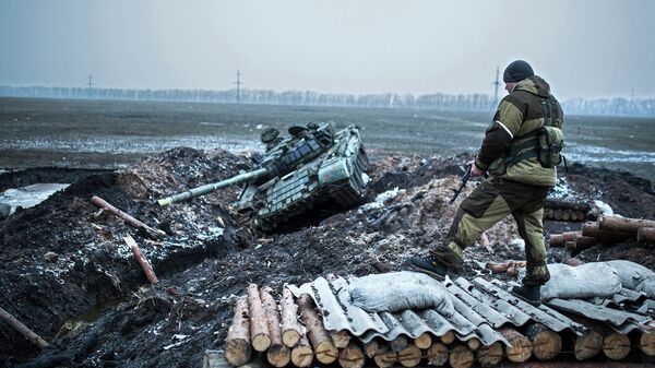 Ополченец стоит у танка украинской армии в Донецкой области. Архивное фото