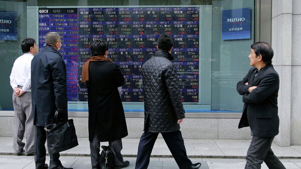 Прохожие в Токио смотрят на экран с биржевыми котировками