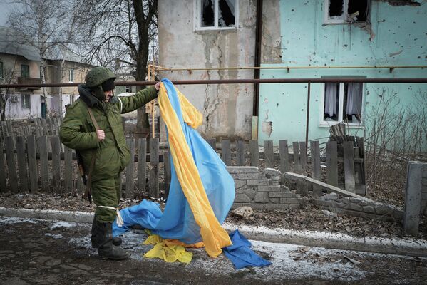 Ополченец держит флаг Украины, брошенный украинскими военными в Углегорске