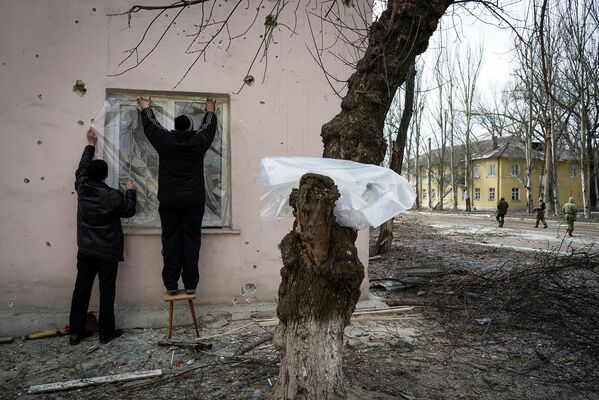 Жители Углегорска заделывают полиэтиленом выбитое в результате обстрела окно