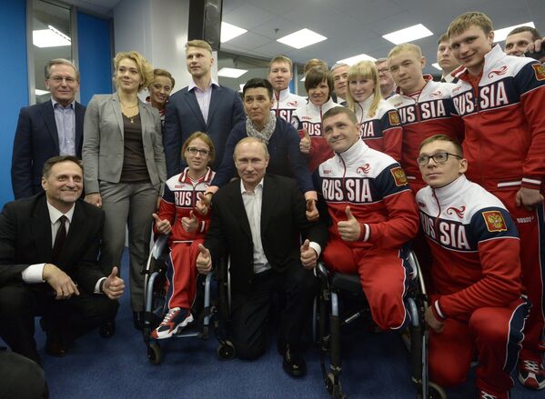 Президент России Владимир Путин (в центре) фотографируется с гостями и спортсменами во время празднования годовщины открытия XXII Олимпийских и Параолимпийских зимних игр во Дворце зимнего спорта Айсберг в Сочи