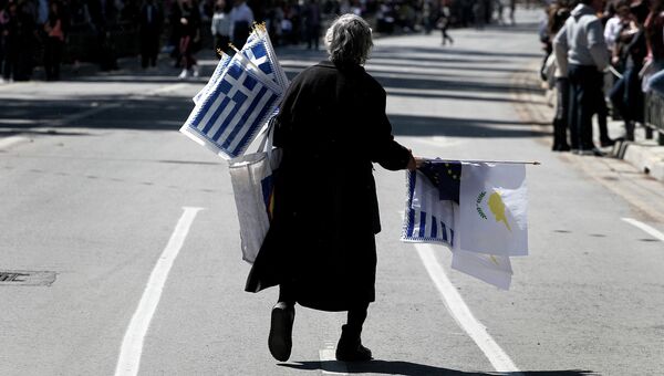 Пожилая женщина с флагами Греции, Кипра и ЕС на улице города Никосия, Кипр. Архивное фото