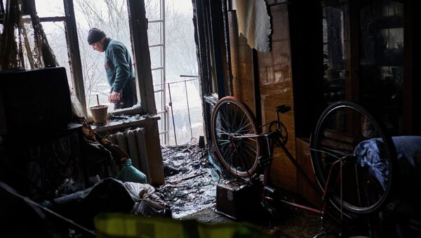 Мужчина в квартире, поврежденной в результате обстрела химического завода и жилого квартала в Донецке