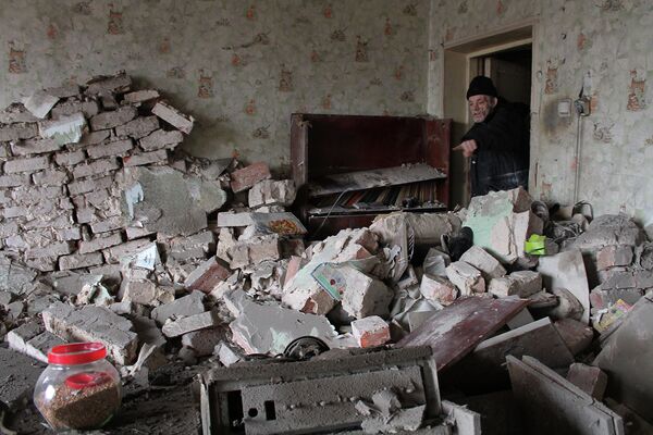 Местный житель показывает разрушения в своей квартире после артиллерийского обстрела Донецка