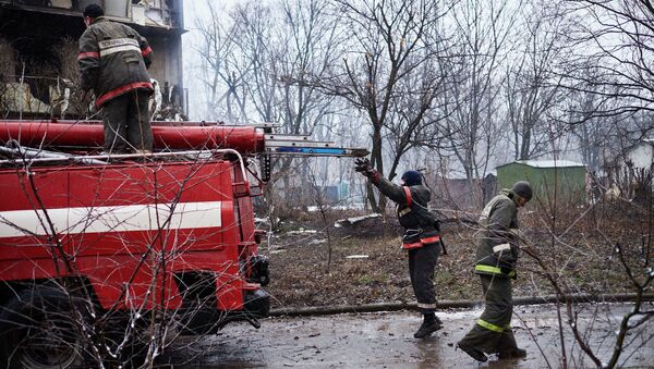 Пожарные у дома, расположенного недалеко от обстрелянного химического завода в Донецке