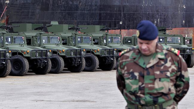 Ливанский военнослужащий рядом с военными автомобилями производства США, доставленными в порт Бейрута. 8 февраля, 2015