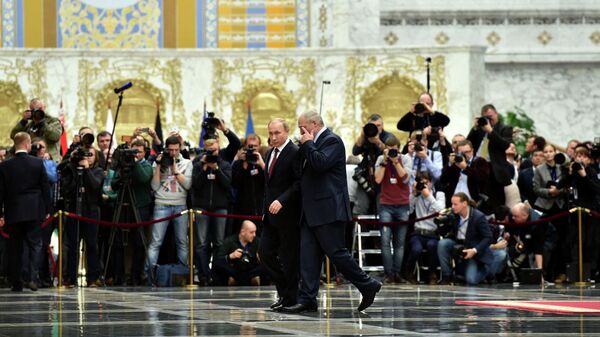 Президент России Владимир Путин и президент Белоруссии Александр Лукашенко проходят мимо журналистов во Дворце независимости в Минске