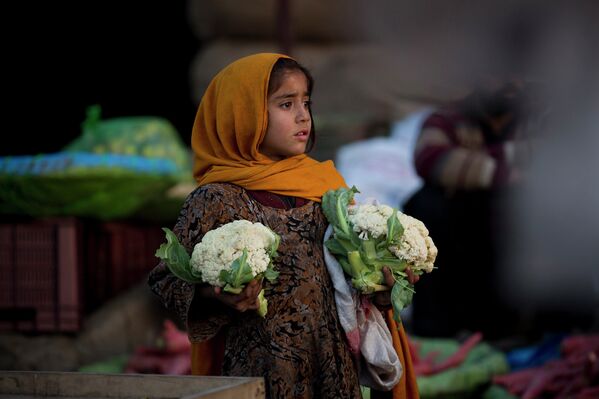 Пакистанская девочка продает капусту на рынке в Исламабаде