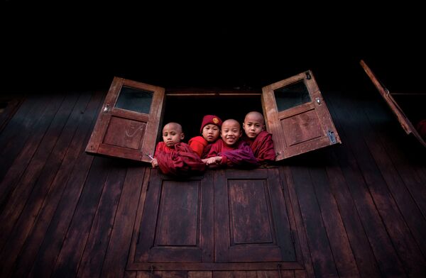Дети смотрят из окна буддийского монастыря
