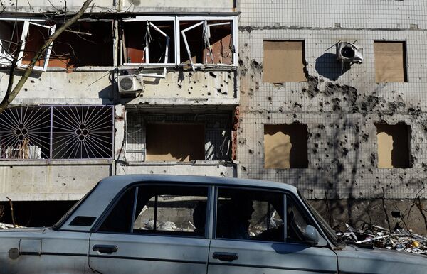 Машина перед поврежденным зданием в Донецке